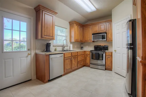 a kitchen with stainless steel appliances granite countertop a refrigerator sink and stove