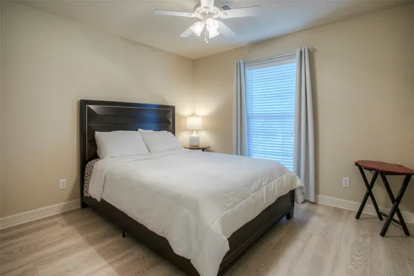 a large bed sitting in a bedroom next to a window