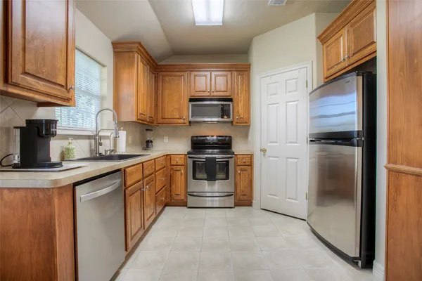 a kitchen with a refrigerator and a stove top oven
