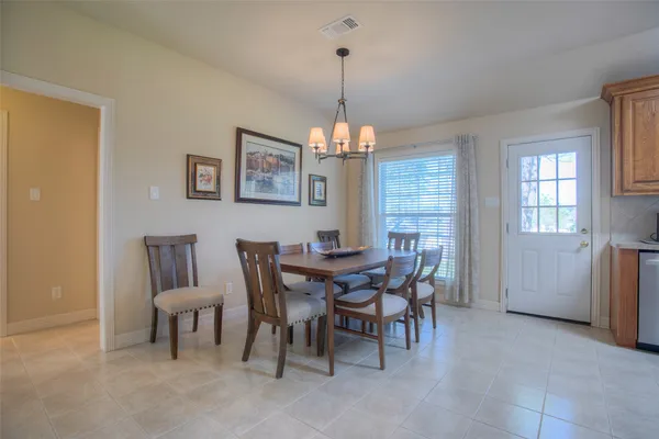 a dining room with furniture a chandelier and window