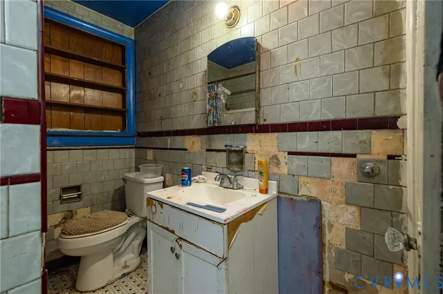 a bathroom with a toilet sink and mirror