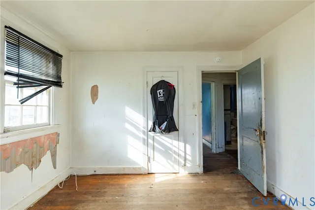 a view of a livingroom with wooden floor and a large window