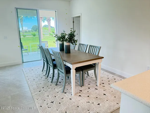 a dining room with furniture and a potted plant