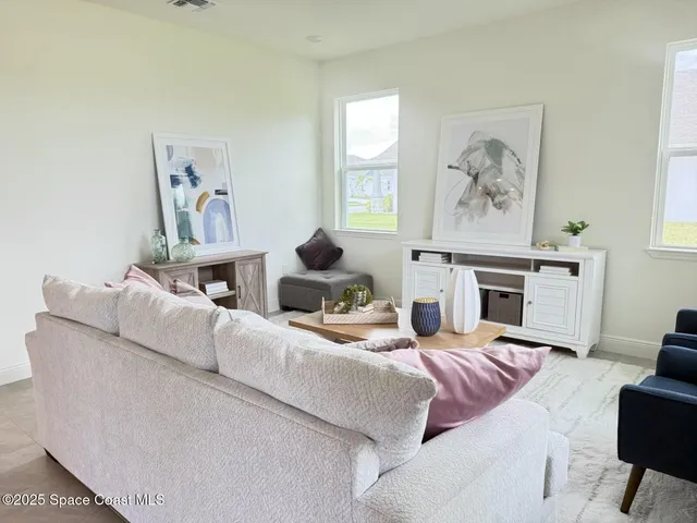 a living room with furniture a fireplace and painting on the wall