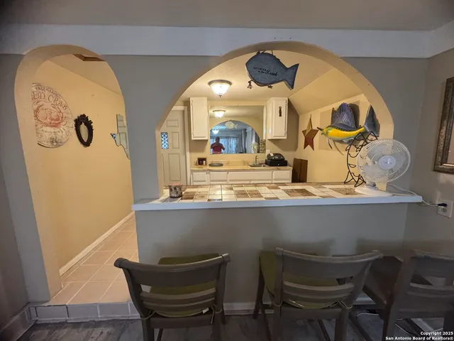 a view of a dining room with furniture a chandelier and wooden floor