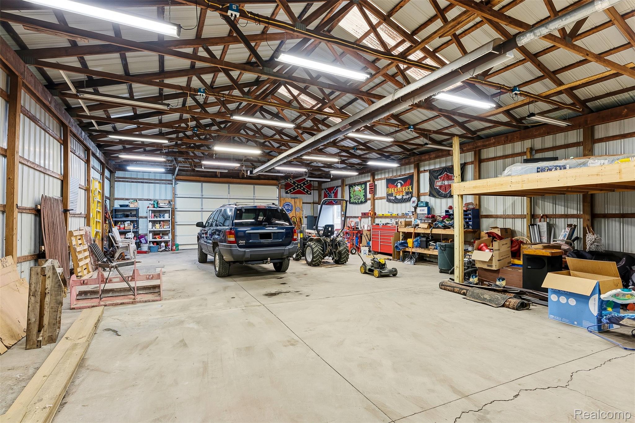 6109 North State Road Davison, MI 48423 - Photo 5 of 39 Spacious heated outbuilding featuring a concrete floor, exposed wood beam ceiling, corrugated metal walls, and multiple fluorescent light fixtures