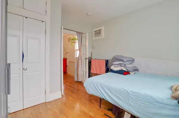 a bedroom with a bed and wooden floor