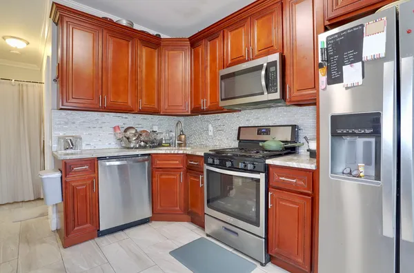 a kitchen with stainless steel appliances granite countertop a stove a sink and a refrigerator