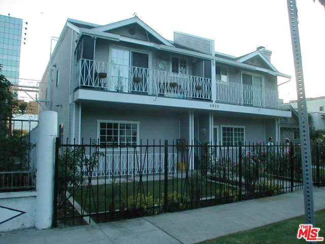a front view of a house with iron fence