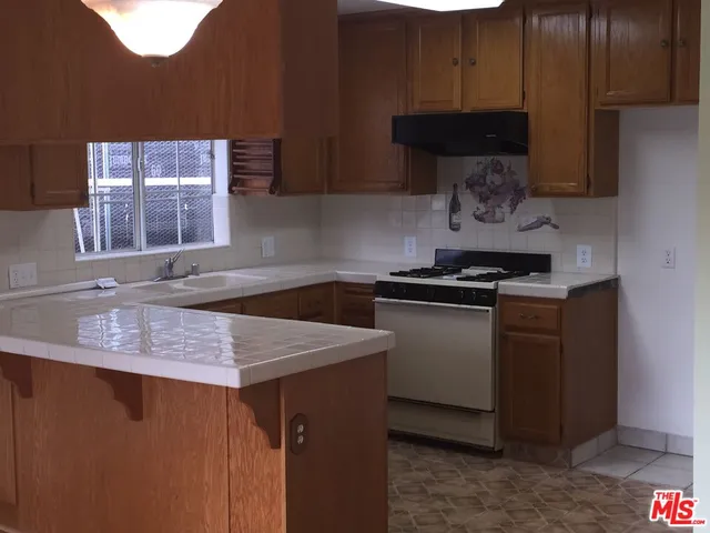 a kitchen with stainless steel appliances a sink dishwasher stove and cabinets