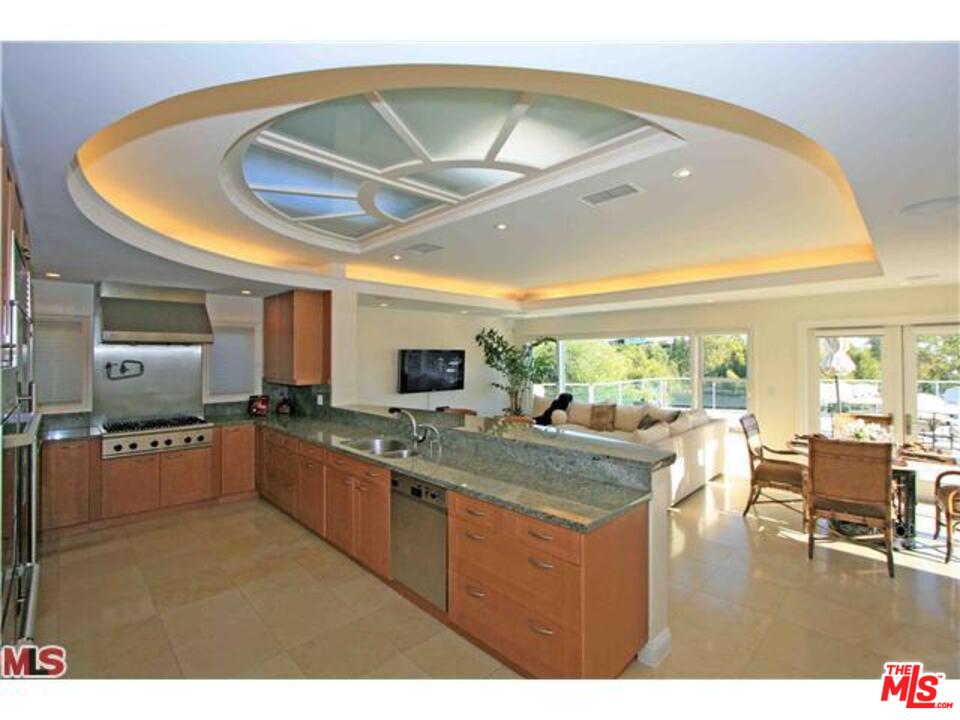 1148 Las Pulgas Road Pacific Palisades, CA 90272 - Photo 3 of 13 a kitchen with stainless steel appliances granite countertop a sink dishwasher stove and oven with wooden floor