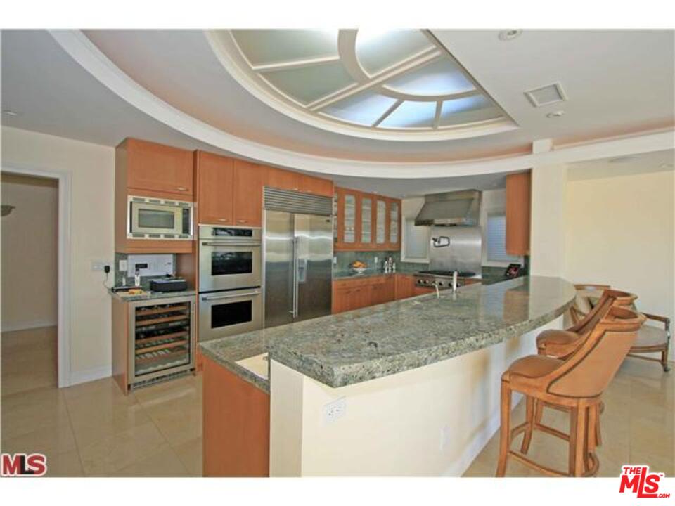 1148 Las Pulgas Road Pacific Palisades, CA 90272 - Photo 4 of 13 a kitchen with stainless steel appliances granite countertop a stove and a refrigerator