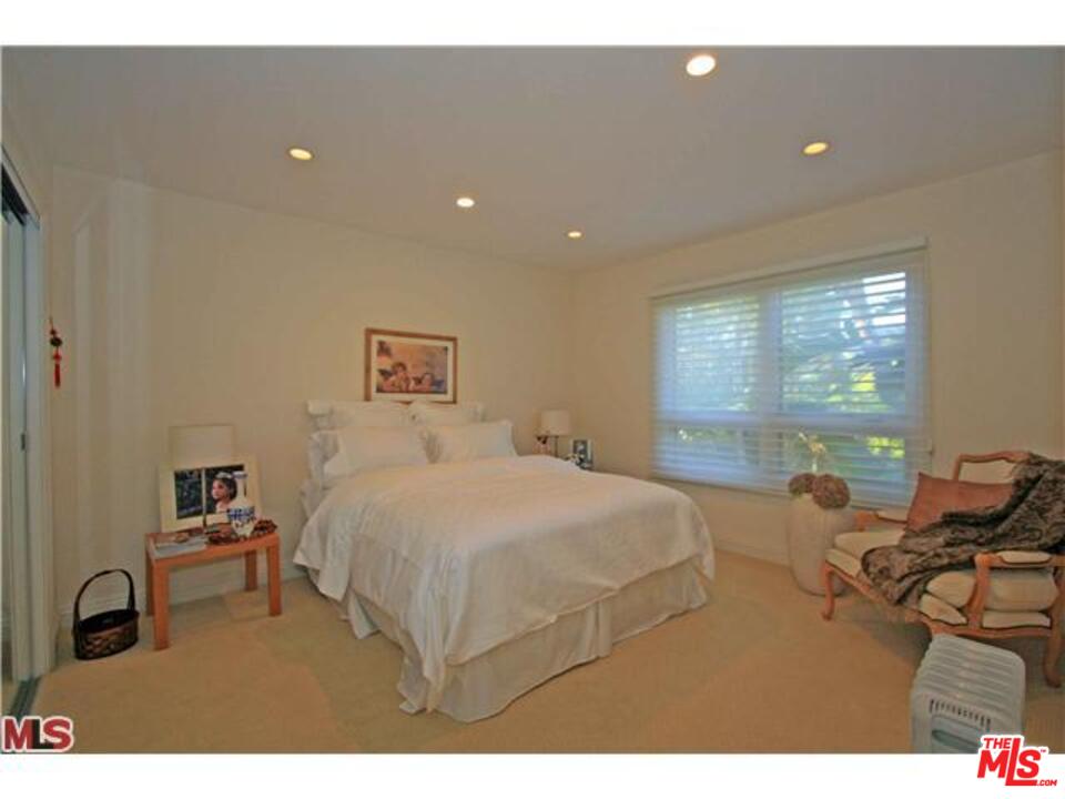 1148 Las Pulgas Road Pacific Palisades, CA 90272 - Photo 10 of 13 a bedroom with a bed and large windows