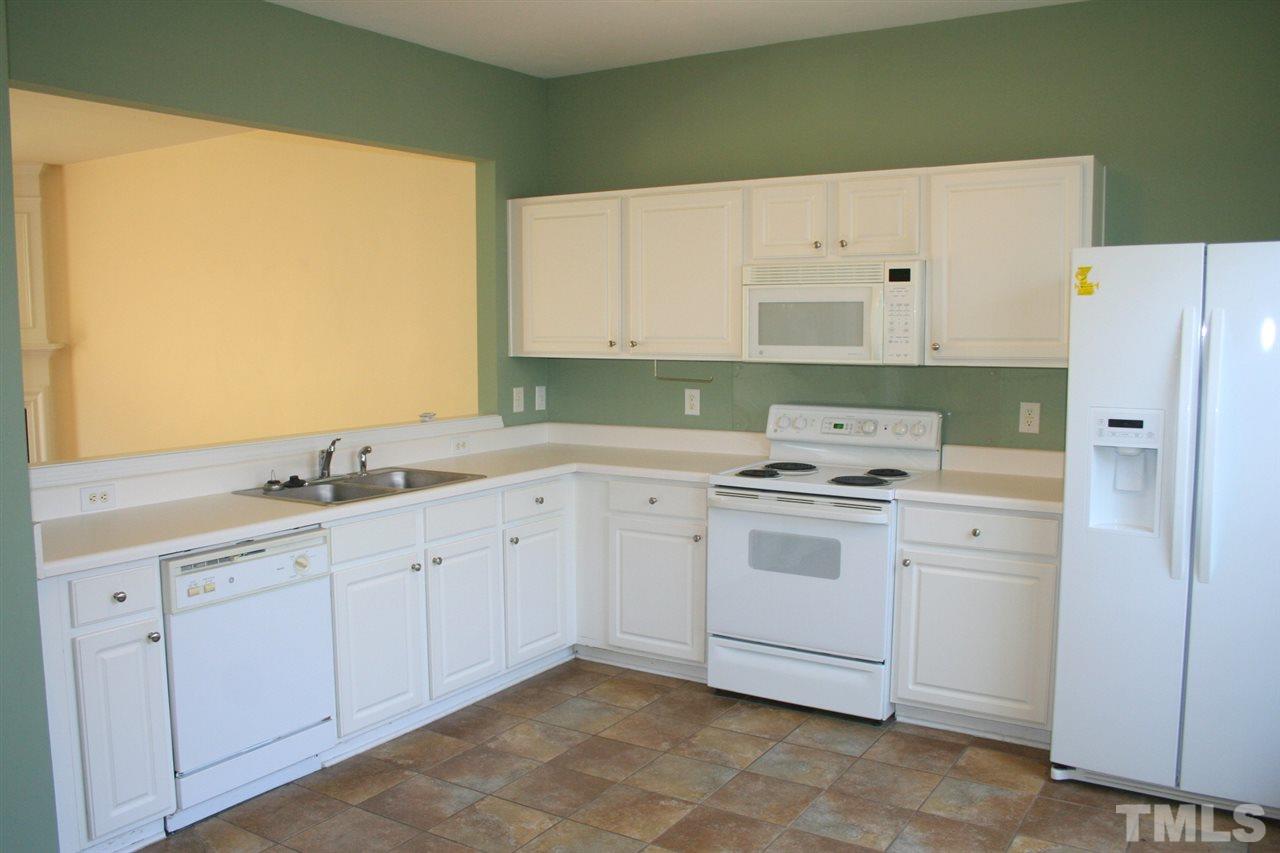 5025 Echo Ridge Road Raleigh, NC 27612 - Photo 6 of 18 a kitchen with white cabinets and white appliances