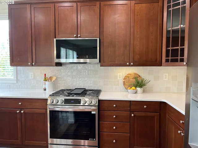 a kitchen with granite countertop wooden cabinets and stainless steel appliances