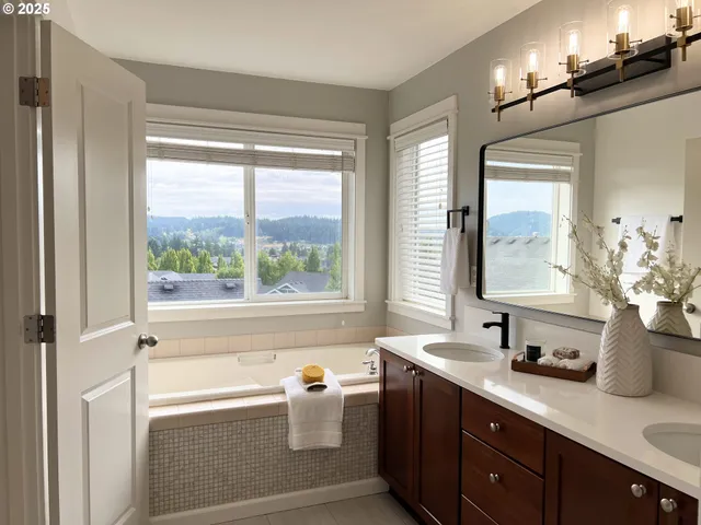 a bathroom with a tub a sink and mirror