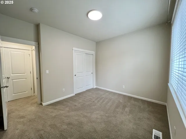an empty room with windows and closet
