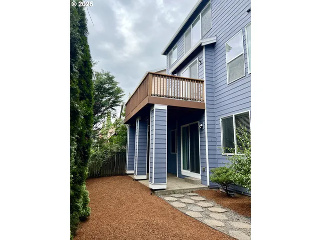 a view of a house with a yard and potted plants