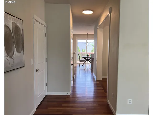 a view of a hallway with wooden floor and dining room