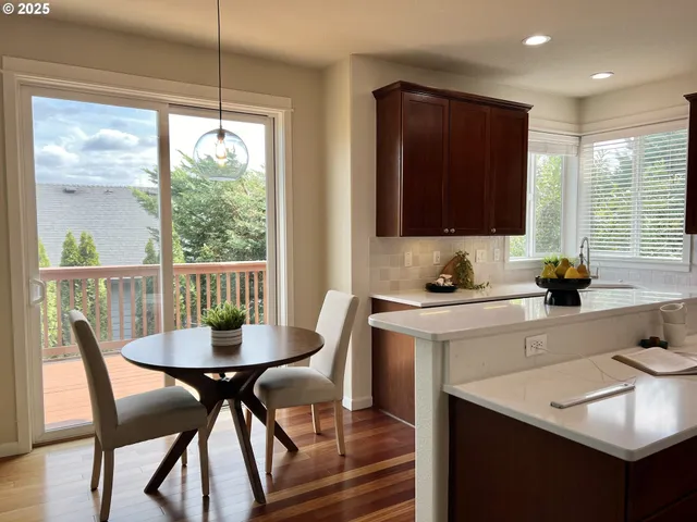 a kitchen with a dining table chairs and white cabinets