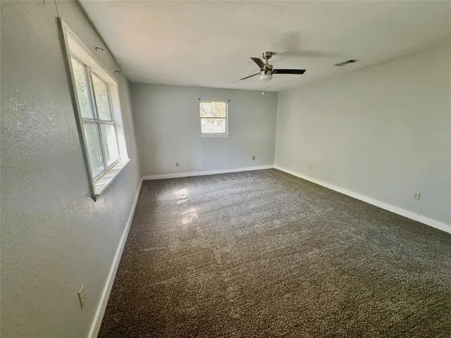 an empty room with windows and hardwood floor
