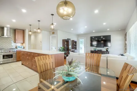 a living room with furniture a flat screen tv and kitchen view
