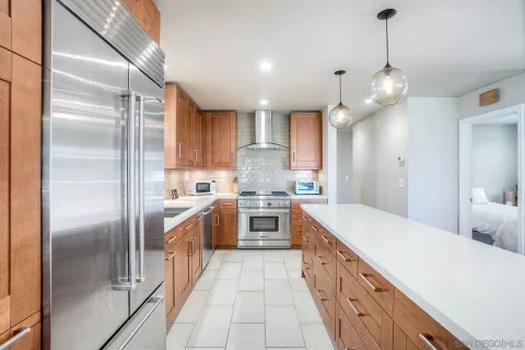 a large kitchen with cabinets a sink and stainless steel appliances