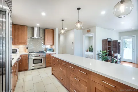 a large kitchen with granite countertop a large counter top space appliances and cabinets