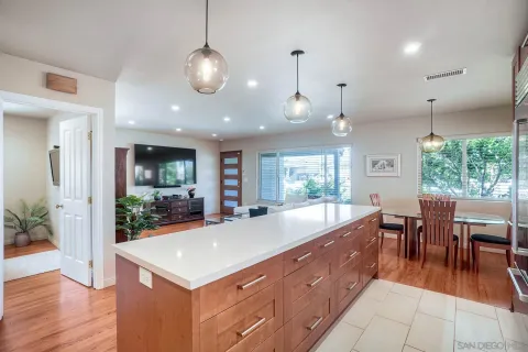 a large kitchen with kitchen island a large center island and a wooden floor