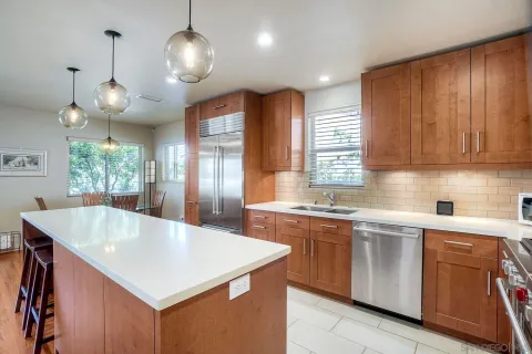 a kitchen with stainless steel appliances granite countertop a sink a stove and a refrigerator
