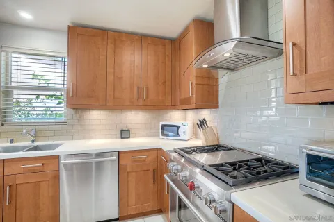 a kitchen with stainless steel appliances a sink a stove and cabinets