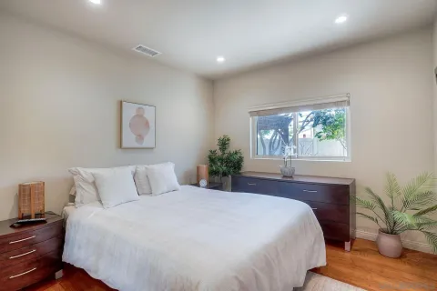 a bedroom with a large bed and a potted plant