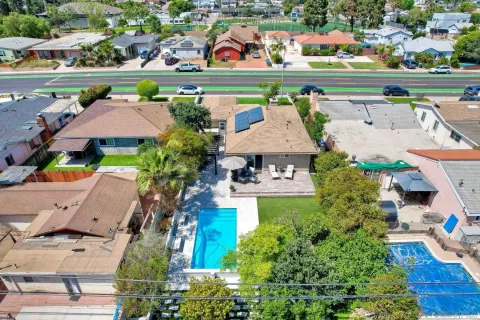 an aerial view of a city with lots of residential buildings ocean and mountain view in back