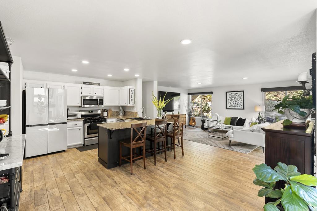 2225 Baxter Canyon Road Vista, CA 92081 - Photo 11 of 46 a kitchen with stainless steel appliances kitchen island granite countertop a refrigerator a stove a sink a dining table and chairs with wooden floor
