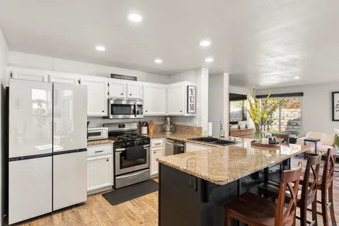 a kitchen with granite countertop a sink stove and cabinets