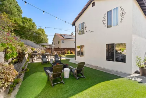 a view of a patio with table and chairs with a yard and plants
