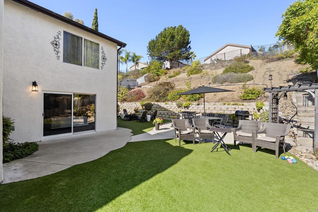 2225 Baxter Canyon Road Vista, CA 92081 - Photo 36 of 46 a view of a patio with table and chairs with a yard and plants