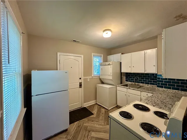 a kitchen with a refrigerator and a stove top oven