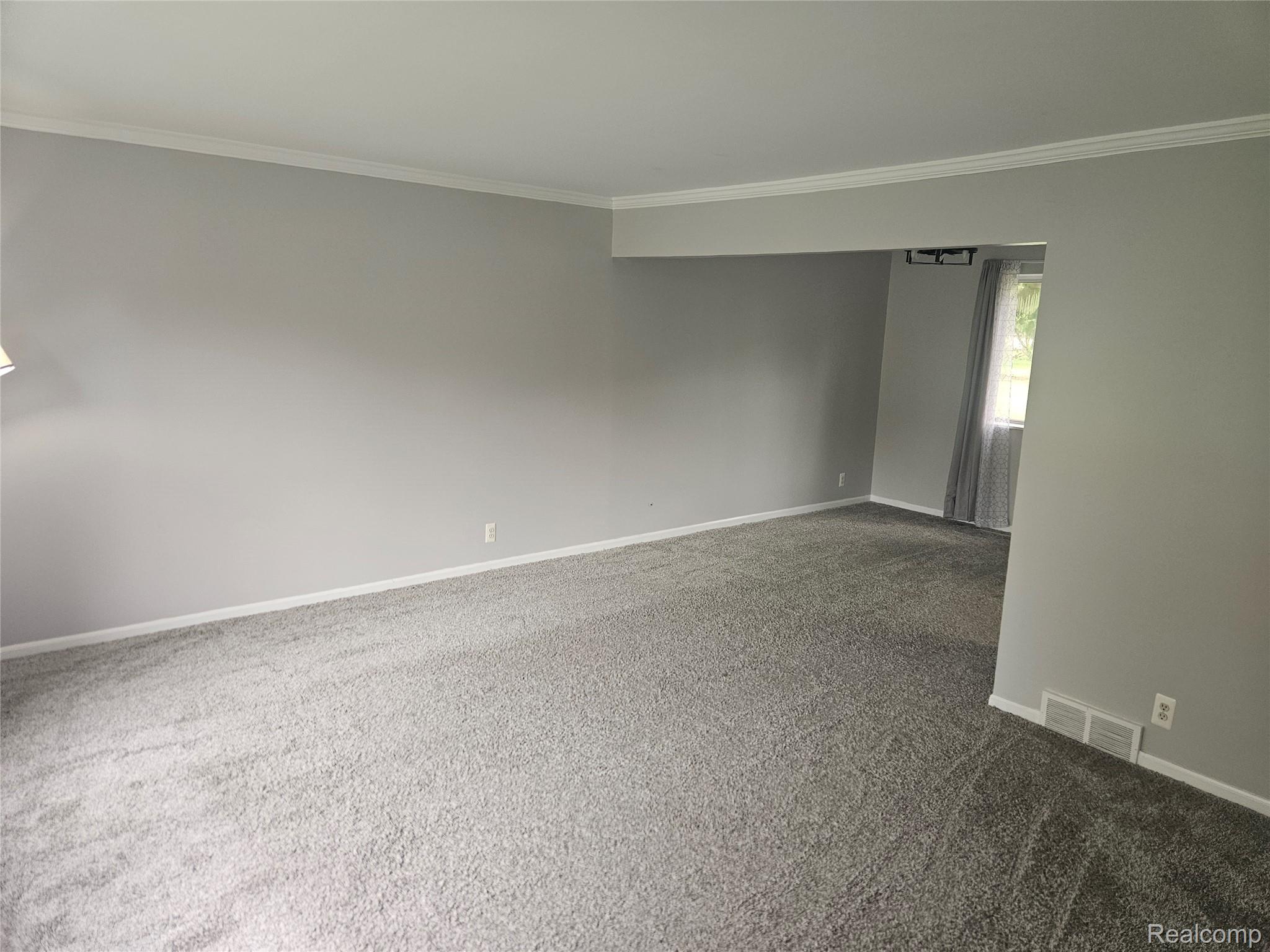 1210 Bay Ridge Drive Highland, MI 48356 - Photo 2 of 25 Carpeted spare room with crown molding
