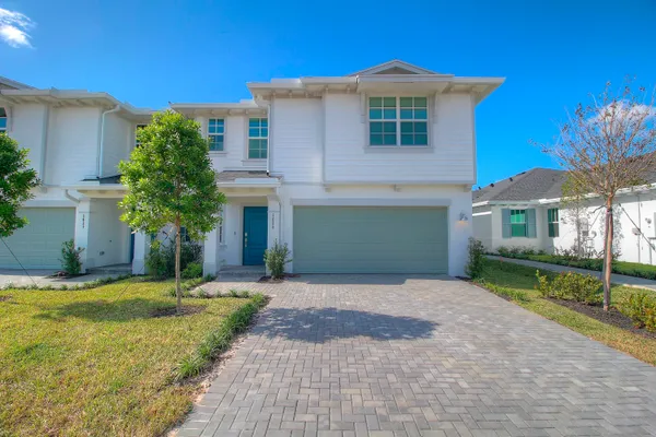 a front view of a house with a garden and yard