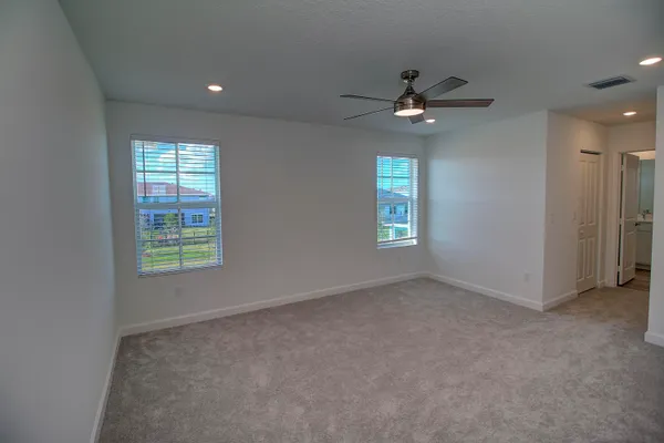 en empty room with windows and ceiling fan