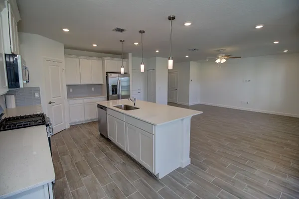 a kitchen with a sink a counter top space stainless steel appliances and cabinets