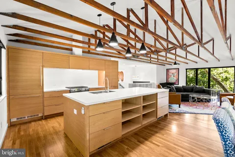 a view of a kitchen with kitchen island a sink stove and wooden floor