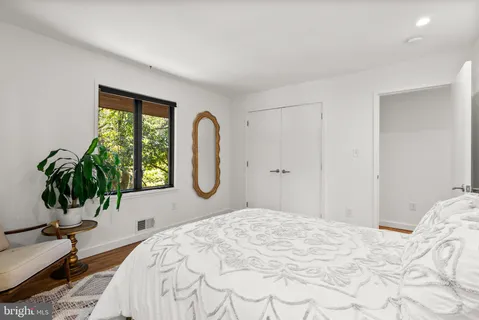 a bedroom with a bed and a potted plant