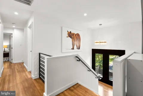 a view of hallway with stairs and wooden floor