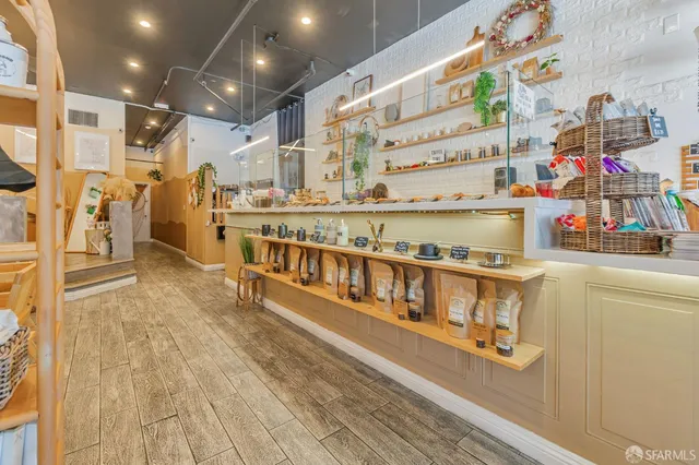 a large white kitchen with stainless steel appliances wooden floor and a counter top space