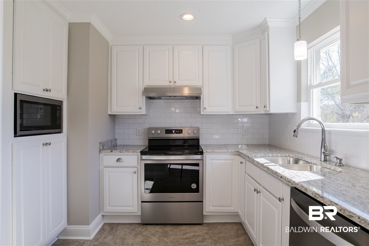 9141 Semmes Court Semmes, AL 36575 - Photo 10 of 28 Lots of pretty white custom cabinets and pantry.