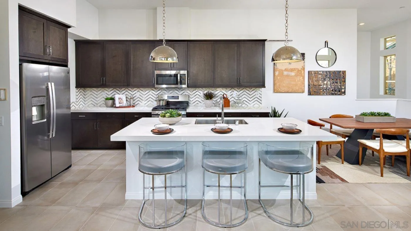 2193 Trevi Circle Chula Vista, CA 91913 - Photo 4 of 16 a kitchen with stainless steel appliances a table chairs and chandelier