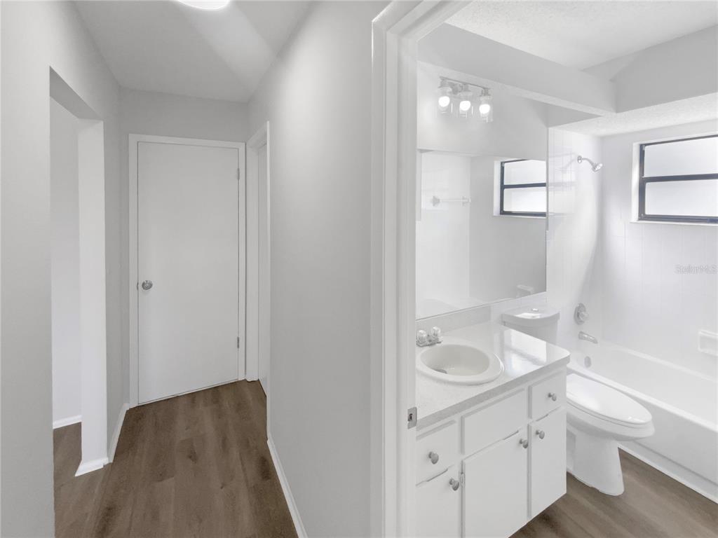 7846 Cayuga Drive New Port Richey, FL 34653 - Photo 16 of 32 a bathroom with a granite countertop sink a toilet and shower