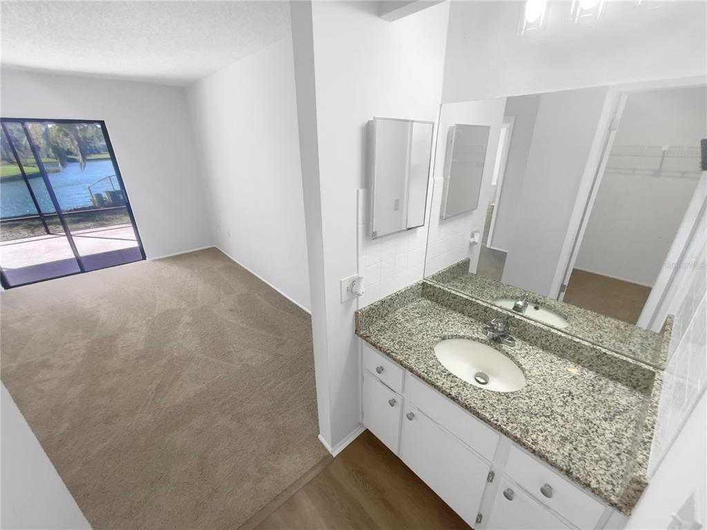 7846 Cayuga Drive New Port Richey, FL 34653 - Photo 21 of 32 a bathroom with a granite countertop sink and a mirror